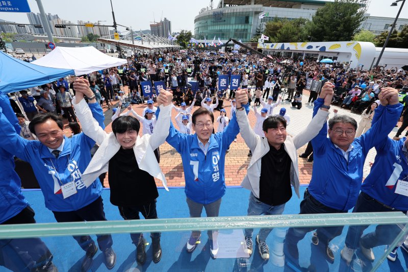 [춘천=뉴시스] 조성우 기자 = 이재명 더불어민주당 대선후보가 30일 오후 강원 춘천시 춘천역 광장에서 열린 집중유세에서 찬조연설자들과 함께 손을 맞잡고 기념촬영하고 있다. 2025.05.30. xconfind@newsis.com