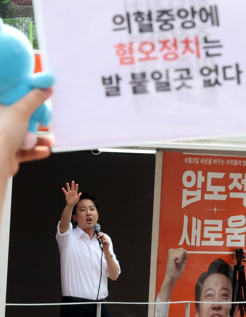 [서울=뉴시스] 추상철 기자 = 30일 오후 서울 동작구 중앙대학교 후문에서 대학생들이 유세를 펼치는 이준석 개혁신당 대선후보를 향해 혐오 발언 규탄 피켓을 들어 보이고 있다. 2025.05.30. scchoo@newsis.com