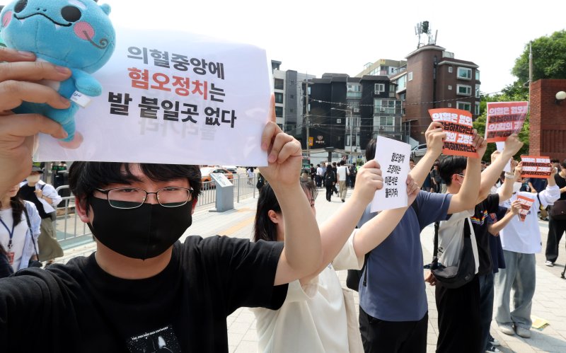 [서울=뉴시스] 추상철 기자 = 30일 오후 서울 동작구 중앙대학교 후문에서 대학생들이 유세를 펼치는 이준석 개혁신당 대선후보를 향해 혐오 발언 규탄 피켓을 들어 보이고 있다. 2025.05.30. scchoo@newsis.com