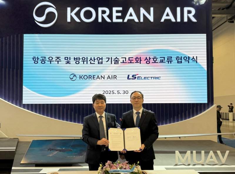 대한항공과 LS일렉트릭은 30일 부산 벡스코에서 열리고 있는 국제해양방위산업전(MADEX)에서 항공우주 및 방위산업 기술 고도화를 위한 협약을 체결했다. 대한항공 임진규 항공우주사업본부장(왼쪽)과 이상준 LS일렉트릭 자동화CIC최고운영책임자가 기념 촬영하고 있는 모습.(대한항공 제공)