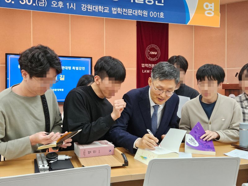 문형배 전 헌법재판소장 권한대행이 30일 오후 강원대학교 법학전문대학원 대강당에서 재학생과 교직원들을 대상으로 '법률가의 길'을 주제로 특별강연을 끝낸 뒤 재학생의 사인 요청에 법전에 사인을 해주고 있다.2025..5.30 한귀섭 기자