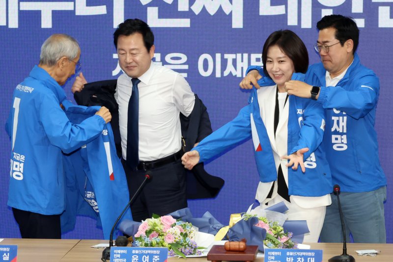 [서울=바카라사이트 벳무브] 조성우 바카라사이트 벳무브 = 윤여준(왼쪽), 박찬대 더불어민주당 상임총괄선대위원장이 26일 오전 서울 여의도 중앙당사에서 열린 입당 환영식에서 김용남(왼쪽 두 번째부터) 전 의원과 허은아 전 개혁신당 대표에게 선거운동복을 입혀주고 있다. 2025.05.26. xconfind@newsis.com