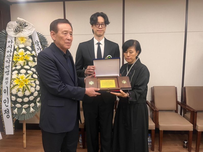 고(故) 장윤창 교수 유족에게 공로패를 전달하는 오한남 대한배구협회장(왼쪽) (출처=연합뉴스)