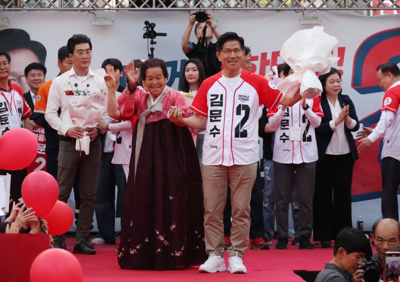 [포항=해외 바카라 사이트] 고승민 기자 = 김문수 국민의힘 대선 후보가 31일 경북 포항 북포항우체국 앞에서 해외 바카라 사이트를 하기 전 포항 시민으로부터 꽃다발을 받으며 기념촬영하고 있다. 2025.05.31. kkssmm99@newsis.com