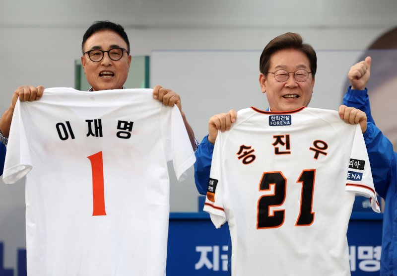 [대전=뉴시스] 조성우 기자 = 이재명 더불어민주당 대선후보가 31일 오후 대전 서구 대전시청 앞 보라매공원에서 열린 바카라 꽁 머니에서 송진우 전 한화이글수 투수가 전달한 유니폼을 들어 보이고 있다. 2025.05.31. xconfind@newsis.com