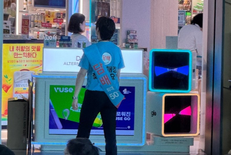 인천국제공항의 한 면세점 직원이 담배 판매 홍보 문구가 인쇄된 티셔츠를 입고 돌아다니고 있다(독자 제공).