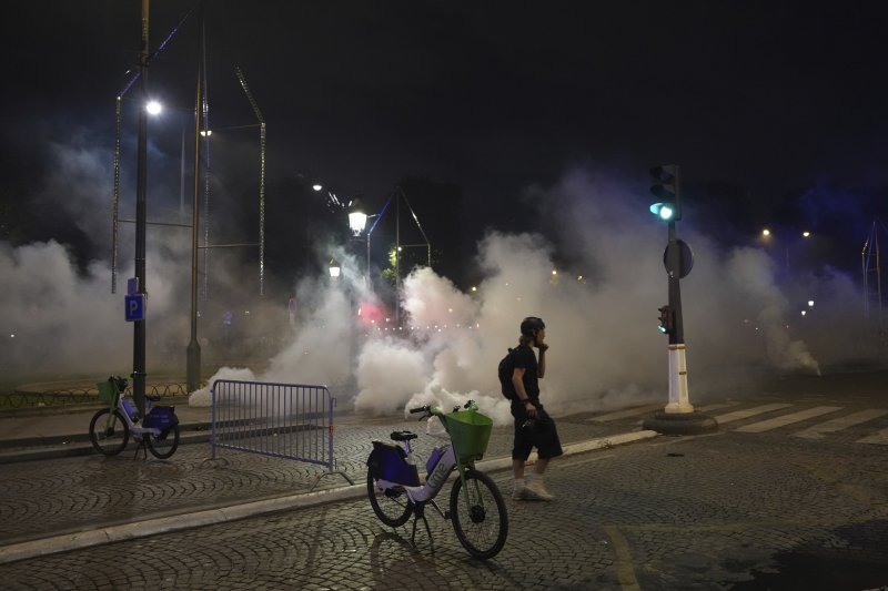 A man walks past tear gas during incidents after the Champions League final soccer match between Paris Saint-Germain and Inter Milan, Sunday, June 1, 2025 in Paris. (AP Photo/Aurelien Morissard)