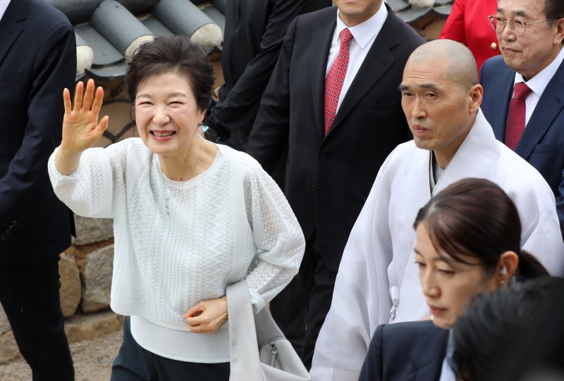 박근혜 전 대통령이 2일 부산 금정구 범어사를 방문해 주지 정오스님과 대웅전으로 향하며 지지자들에게 인사하고 있다. 2025.6.2/뉴스1 ⓒ News1 윤일지 기자