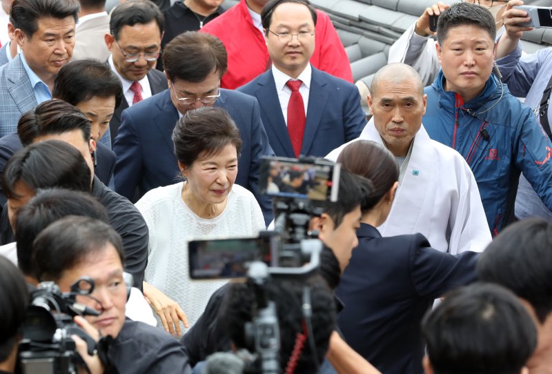 박근혜 전 대통령이 2일 부산 금정구 범어사를 방문해 주지 정오스님과 이동하며 지지자들에게 인사하고 있다. 2025.6.2/뉴스1 ⓒ News1 윤일지 기자