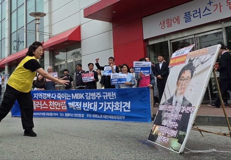 마트 노동자들이 2일 천안시 동남구 홈플러스 천안점 앞에서 열린 폐점 반대 기자회견에서 김병주 MBK파트너스 회장을 규탄하며 얼굴 사진에 물풍선을 던지고 있다. 2025.6.2/뉴스1 ⓒ News1 이시우 기자