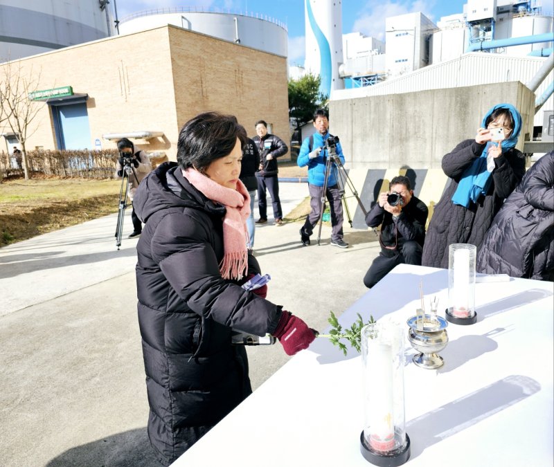 [태안=뉴시스] 김덕진 기자=6일 충남 태안 한국서부발전㈜ 앞에서 청년 비정규직 노동자 고 김용균씨 추모 6주기를 나흘 앞두고 김 씨 어머니 김미숙씨가 현장에 차려진 제사상에 하얀색 국화를 얹고 있다. 사고 당시 24세였던 김 씨는 지난 2018년 12월10일 밤 10시40분께 한국서부발전 태안화력발전소에서 한국발전기술 소속으로 근무 중 컨베이어벨트 끼임 사고로 숨졌다. (사진=독자 제공) 2024.12.06. photo@newsis.com