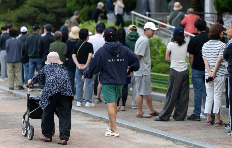 제21대 대통령 선거일인 3일 서울 영등포구 여의도 윤중중학교에 마련된 투표소를 찾은 시민들이 길게 줄 서 있다. 2025.6.3/뉴스1 ⓒ News1 이승배 기자