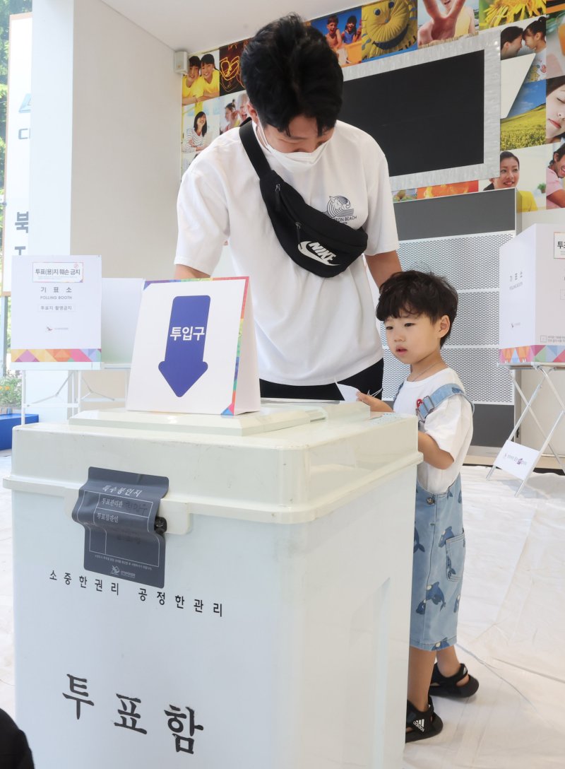 [인천=뉴시스] 전진환 기자 = 제21대 대통령선거일인 3일 오전 인천 미추홀구 한 자동차영업소에 마련된 주안5동 제3투표소에서 한 어린이가 아빵의 투표를 지켜보고 있다 2025.06.03. amin2@newsis.com