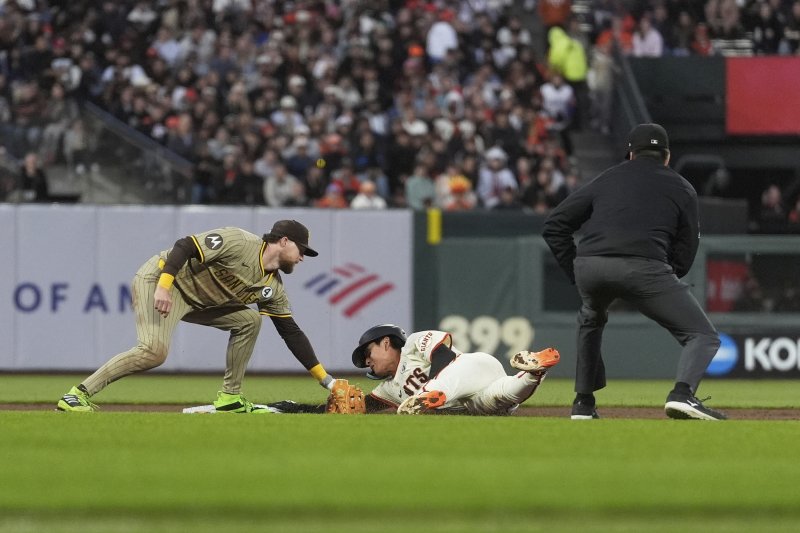 San Francisco Giants' Jung Hoo Lee, middle, steals second base against San Diego Padres second baseman Jake Cronenworth, left, during the sixth inning of a baseball game in San Francisco, Monday, June 2, 2025. (AP Photo/Jeff Chiu)