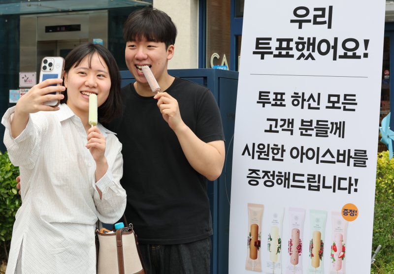 제21대 대통령 선거일가 실시된 3일 대전 유성구 온천동 한 상가에서 토토 바카라한 유권자에게 아이스바를 증정하는 행사를 진행한 가운데 토토 바카라를 마친 유권자가 인증사진을 촬영하고 있다. 2025.6.3/뉴스1 ⓒ News1 김기태 기자