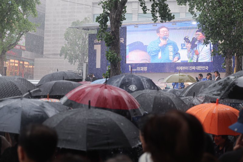[순천=뉴시스] 권창회 기자 = 15일 전남 순천시 연향동 패션의거리에서 열린 바카라사이트 추천 더불어민주당 대선 후보의 유세에서 시민들이 폭우 속에도 이 후보의 연설을 듣고 있다. 2025.05.15. kch0523@newsis.com