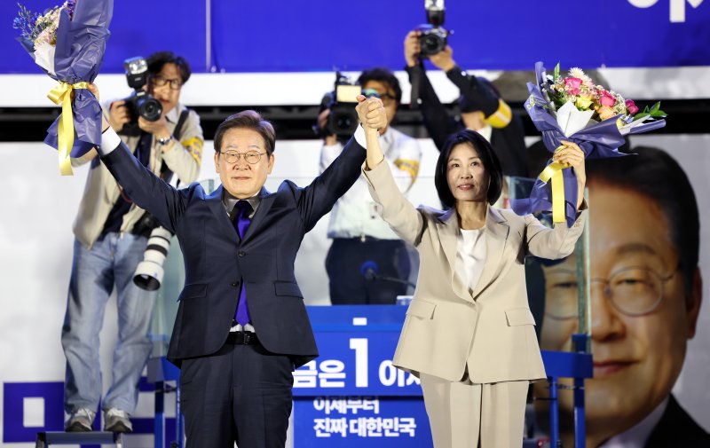 [서울=뉴시스] 조성우 기자 = 바카라사이트 굿모닝 대통령과 김혜경 여사가 4일 오전 서울 여의도 국회 앞에서 열린 국민 개표방송 행사에서 꽃다발을 받은 뒤 시민들을 향해 인사하고 있다. 2025.06.04. xconfind@newsis.com