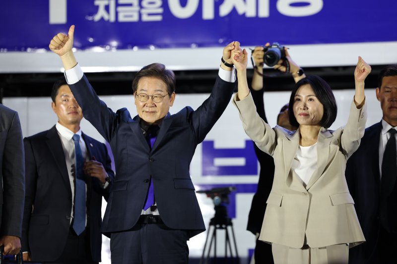 당선이 확실시 되는 이재명 더불어민주당 대선후보와 김혜경 여사가 4일 오전 서울 여의도 국회 앞에서 열린 토토 사이트 바카라 개표방송 행사에서 꽃다발을 받은 뒤 시민들을 향해 인사하고 있다. (공동취재) 2025.6.4/토토 사이트 바카라1 ⓒ News1 안은나 기자