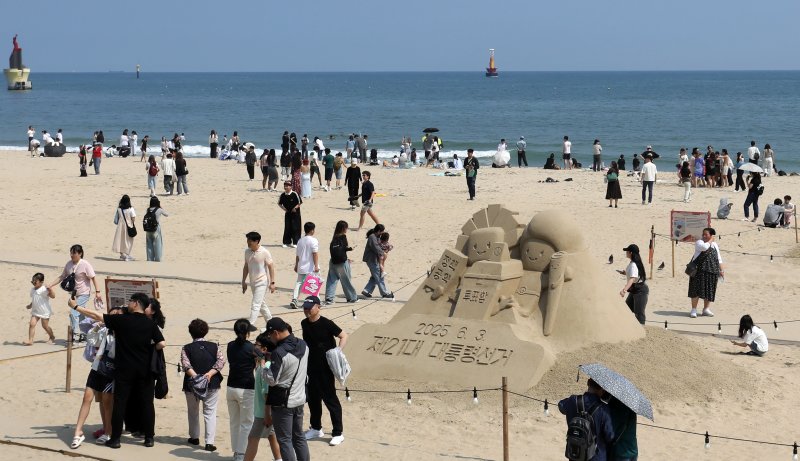 21대 대통령 선거일이자 초여름 바카라사이트 윈윈를 보인 3일 오후 부산 해운대해수욕장에 설치된 대통령 선거 홍보 모래작품 뒤로 시민, 관광객 등이 더위를 식히고 있다. 2025.6.3/바카라사이트 윈윈1 ⓒ News1 윤일지 기자