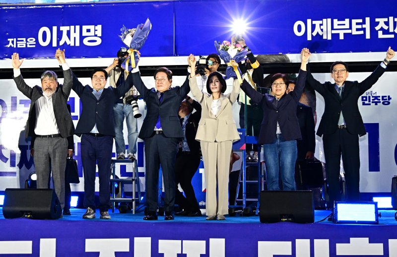 제21대 대통령 선거에서 바카라사이트 굿모닝이 확실해진 이재명 더불어민주당 후보가 김혜경 여사와 4일 오전 서울 여의도 국회 앞에 마련된 개표방송 야외 무대에 올라 꽃다발을 들어보이고 있다. (공동취재) 2025.6.4/바카라사이트 굿모닝1 ⓒ News1 안은나 기자