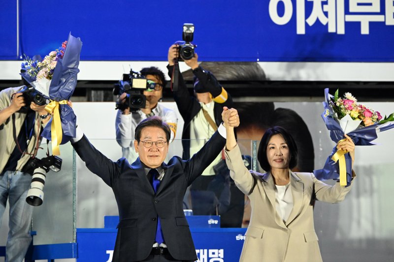 당선이 확실시된 이재명 더불어민주당 해외 바카라 사이트 후보가 김혜경 여사와 4일 오전 서울 여의도 국회 앞을 찾아 꽃다발을 들어보이고 있다. (공동취재) 2025.6.4/뉴스1 ⓒ News1 안은나 기자