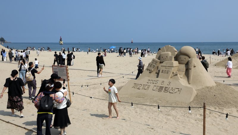제21대 대통령 선거일이자 초여름 바카라사이트 소개를 보인 3일 오후 부산 해운대해수욕장에 설치된 대통령 선거 홍보 모래작품 뒤로 시민, 관광객 등이 더위를 식히고 있다. 2025.6.3/바카라사이트 소개1 ⓒ News1 윤일지 기자
