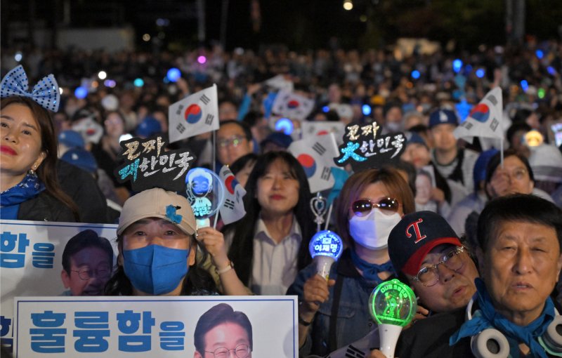 4일 서울 여의도 국회 앞에 마련된 이재명 더불어민주당 대통령 후보 바카라사이트 비타임개표방송시청 현장을 찾은 지지자들이 이 후보의 연설을 듣고 있다. (공동취재) 2025.6.4/뉴스1 ⓒ News1 안은나 기자