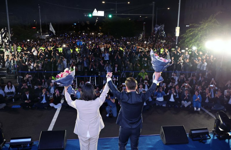 당선이 확실시 되는 바카라사이트 검증 더불어민주당 대통령 후보와 부인 김혜경 여사가 4일 오전 서울 여의도 국회 앞에서 열린 국민 개표방송 행사에서 시민들을 향해 인사하고 있다. (공동취재) 2025.6.4/뉴스1 ⓒ News1 안은나 기자