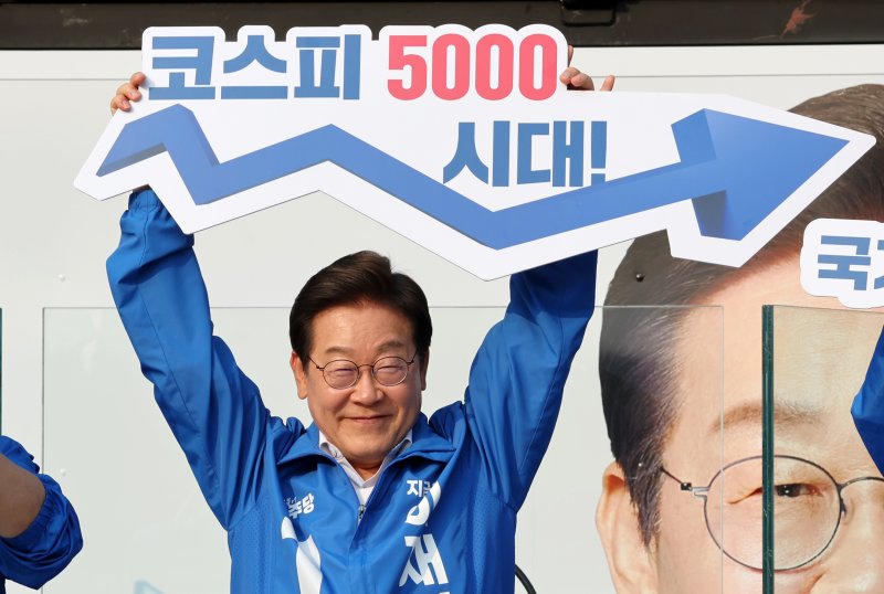 [서울=뉴시스] 조성우 기자 = 이재명 대통령이 후보 시절 선거 유세에서 '코스피 5000 시대' 팻말을 들고 경제회복 퍼포먼스를 하고 있는 모습. 2025.05.29. xconfind@newsis.com