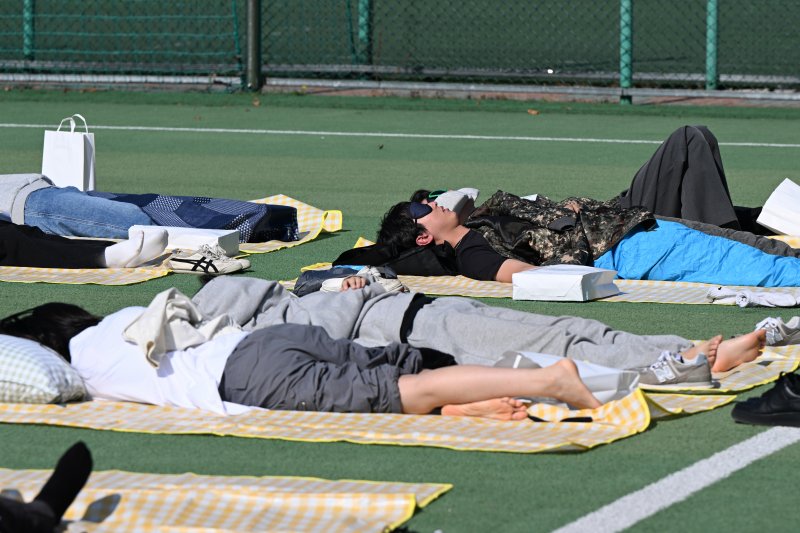 [광주=뉴시스] 박기웅 기자 = 30일 오후 광주 동구 조선대학교 운동장에서 열린 '대놓고 잠자기 대회'에서 참가자들이 낮잠을 자고 있다. 2024.10.30. pboxer@newsis.com