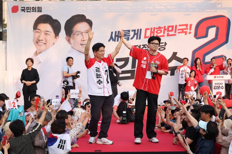 [서울=뉴시스] 권창회 기자 = 한동훈 전 국민의힘 대표가 지난달 26일 서울 도봉구 방학사거리 인근에서 열린 김문수 국민의힘 대선 후보의 집중유세에 지원나와 김 후보와 손을 맞잡고 있다. (공동취재) 2025.05.26. photo@newsis.com