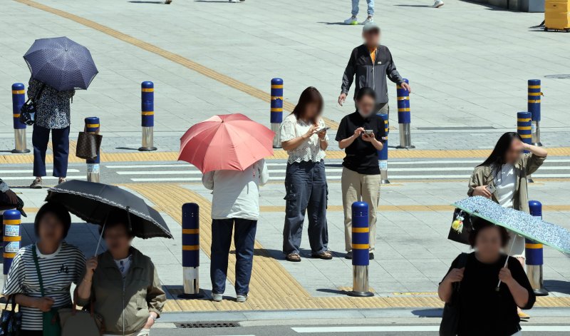 [부산=뉴시스] 하경민 기자 = 무더운 날씨를 보인 4일 부산 동구 부산역 광장 횡단보도에서 시민들이 양산을 쓰고 길을 건너고 있다. 2025.06.04. yulnetphoto@newsis.com
