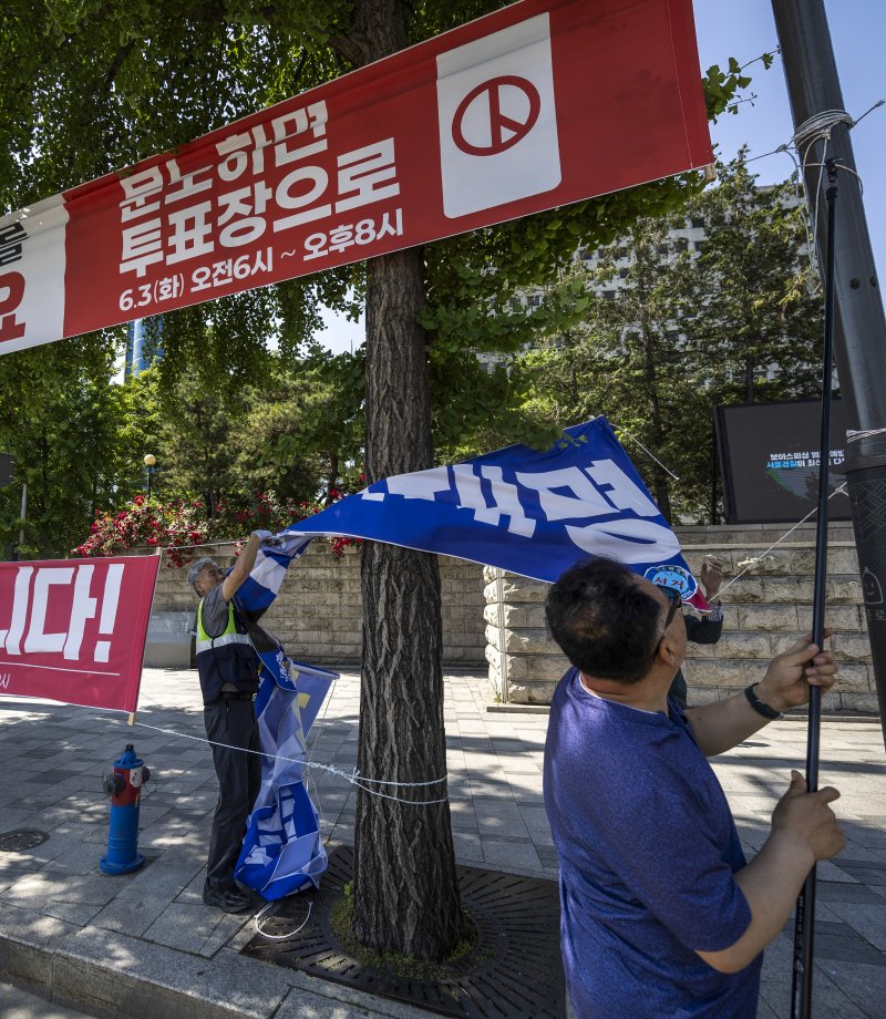 [서울=뉴시스] 정병혁 기자 = 제21대 대통령 선거가 끝난 4일 서울 종로구 광화문네거리에서 종로구청 관계자들이 선거 현수막을 철거하고 있다. 2025.06.04. jhope@newsis.com
