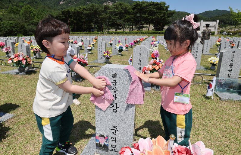 현충일을 하루 앞둔 5일 대전 유성구 국립대전현충원에서 어린이집 원생들이 추모를 마치고 묘비를 닦고 있다. 2025.6.5/뉴스1 ⓒ News1 김기태 기자