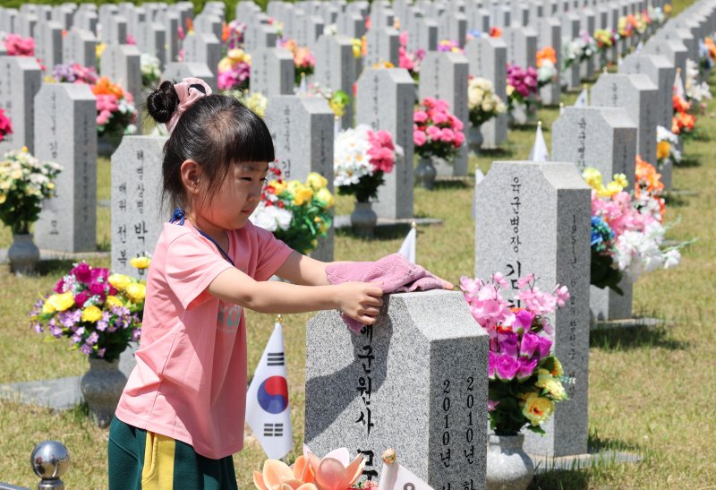 현충일을 하루 앞둔 5일 대전 유성구 국립대전현충원에서 어린이집 원생들이 추모를 마치고 묘비를 닦고 있다. 2025.6.5/뉴스1 ⓒ News1 김기태 기자