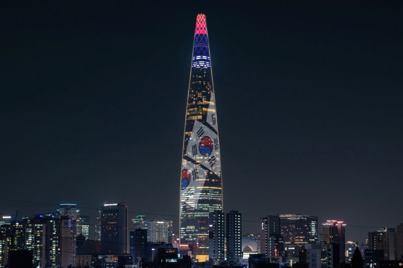 [서울=뉴시스] 롯데월드타워는 현충일(6월 6일)을 맞아 외벽 미디어파사드에 현충일의 의미를 되새길 수 있는 콘텐츠를 선보인다고 5일 밝혔다.이번 콘텐츠는 6일 오후 8시부터 10시까지 매 정각부터 10분 단위로 송출되며, 태극기가 휘날리는 장면과 거대한 태극 문양을 번갈아 연출하여 순국선열과 호국영령의 뜻을 기린다. (사진=롯데물산 제공) 2025.06.05. photo@newsis.com *재판매 및 DB 금지