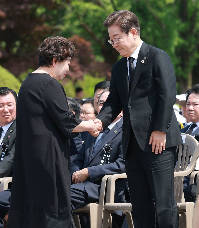 [서울=뉴시스] 고범준 기자 = 이재명 대통령이 6일 서울 동작구 국립서울현충원에서 열린 제70회 현충일 추념식에서 유해 발굴로 다시 아버지(고 송영환 일병)를 만난 송재숙 씨와 악수하고 있다. 2025.06.06. bjko@newsis.com