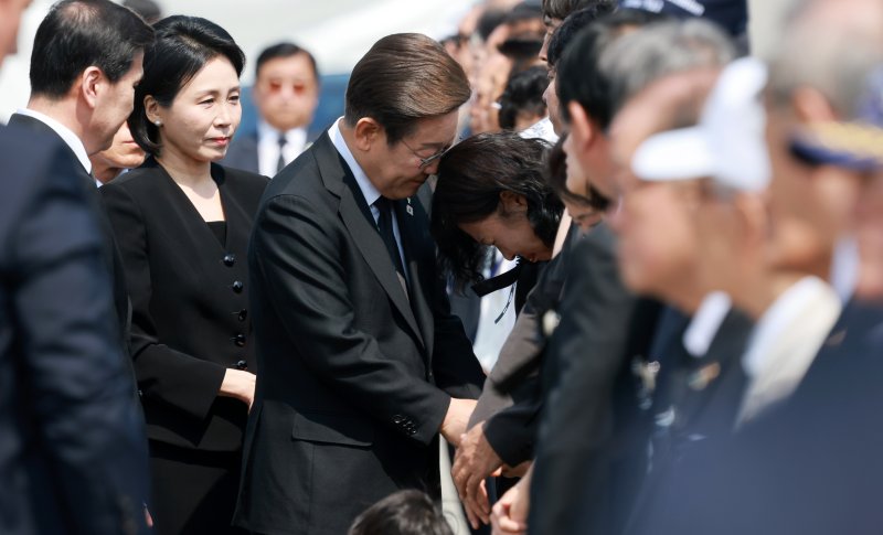 [서울=뉴시스] 고범준 기자 = 이재명 대통령이 6일 서울 동작구 국립서울현충원에서 열린 제70회 현충일 추념식에 입장하며 한 유족을 위로하고 있다. 2025.06.06. bjko@newsis.com