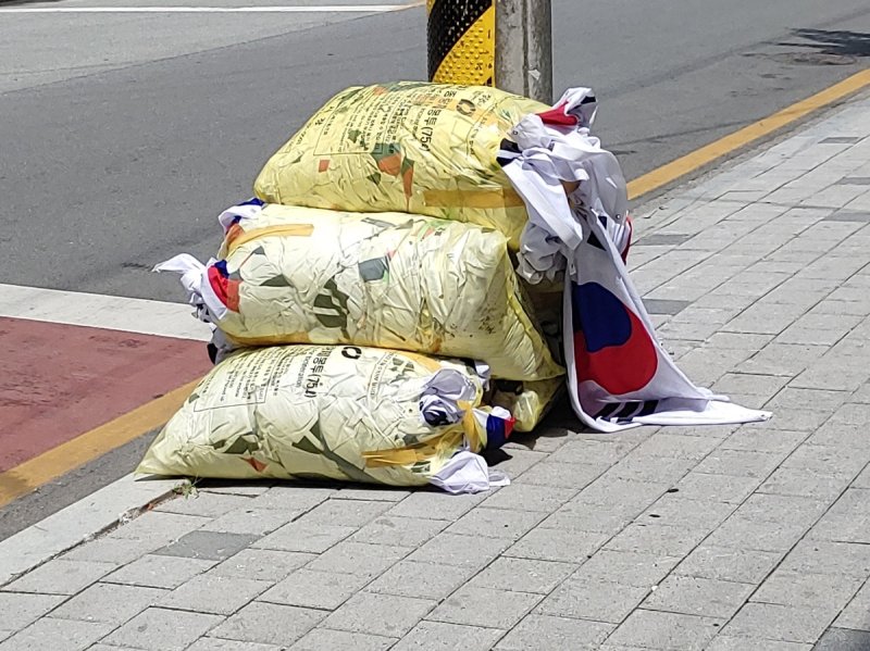 쓰레기봉투에 담겨 버려진 태극기 (출처=연합뉴스)