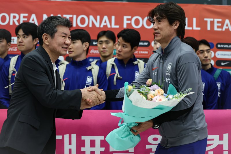 홍명보 감독이 6일 이라크와 북중미 월드컵 예선경기를 마치고 인천국제공항 제1터미널을 통해 귀국하며 정몽규 대한축구협회장에게 꽃을 받고 있다. 대표팀은 이라크와 원정경기에서 2대0으로 승리하며 11회 연속 월드컵 본선 진출을 확정했다. 2025.6.6/뉴스1 ⓒ News1 김도우 기자