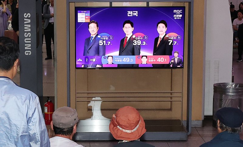제21대 대통령 선거 투표일인 3일 오후 서울 중구 서울역에서 유권자들이 방송3사 출구조사 결과를 확인하고 있다. 2025.6.3/뉴스1 ⓒ News1 김진환 기자