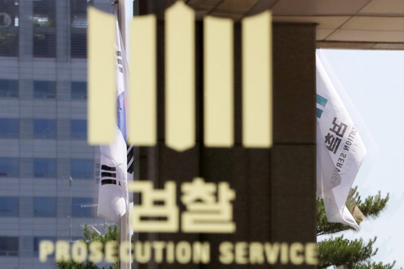 22일 오전 서울 서초구 서울중앙지검 청사 검찰 로고 뒤로 펄럭이는 태극기와 검찰 깃발이 비춰 보이고 있다다. 2018.6.22/뉴스1 ⓒ News1 박지수 기자