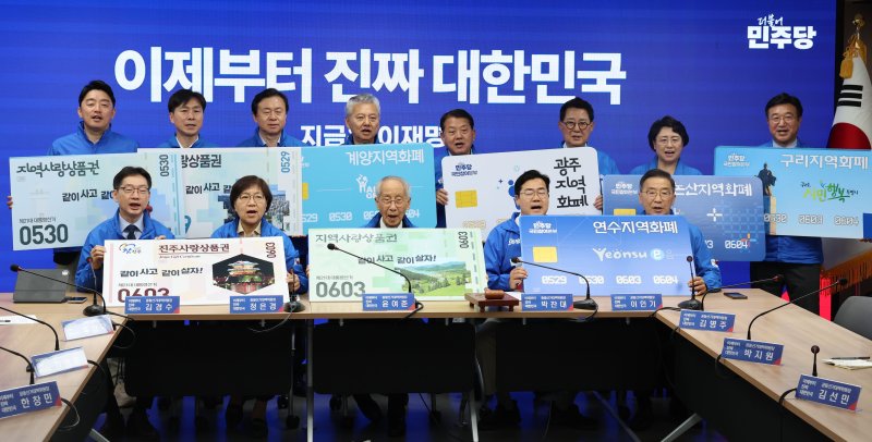 [서울=뉴시스] 권창회 기자 = 윤여준, 박찬대 더불어민주당 상임총괄선거대책위원장을 비롯한 선대위원장들이 21일 서울 여의도 더불어민주당 당사에서 열린 중앙선거대책위원회의 시작에 앞서 지역화폐 사용을 촉구하는 퍼포먼스를 하고 있다. 2025.05.21. kch0523@newsis.com