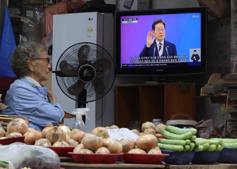 [서울=뉴시스] 황준선 기자 = 사진은 지난 4일 오전 서울 서대문구 인왕시장에서 상인이 이재명 대통령 취임식을 시청하고 있는 모습. 2025.06.04. hwang@newsis.com