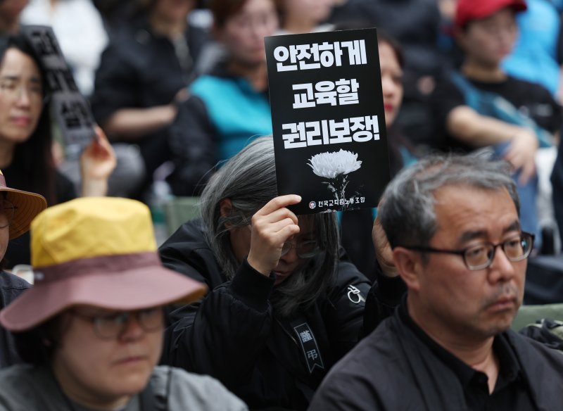 [서울=뉴시스] 김진아 기자 = 전국교직원노동조합(전교조)은 제주의 한 중학교에서 학생 측의 민원에 시달리던 고(故) 현승준 교사가 숨진 사건에 대한 엄정 수사 및 순직 인정 촉구 서명운동 결과를 9일 발표했다. 사진은 5월 24일 서울 종로구 고궁박물관 서측에서 열린 전국교직원노동조합(전교조) 창립 36주년 전국 교사결의대회에서 참가자들이 손팻말을 들고 있는 모습.이들은 안전하게 교육할 권리, 악성 민원 해결, 교육공공성 강화, 정치기본권 쟁취 등을 요구했다. 2025.05.24. bluesoda@newsis.com