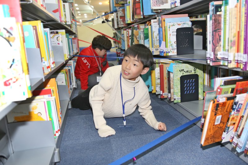 18일 오후 경북 영천시립도서관서 열린 종횡무진 도서관 탐험 이벤트에서 한 어린이가 '미션 임파서블' 게임을 하면서 즐거운 시간을 보내고 있다.도서관을 즐거운 추억이 있는 공간으로 만들어 어린이들이 책과 친근감을 느낄 수 있도록 행사를 기획한 영천시립도서관은 이날 저녁 도서관을 야간개방하고 놀이터로 제공했다. 2019.1.19/뉴스1 ⓒ News1 정우용 기자