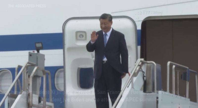 [서울=뉴시스] 시진핑 중국 국가주석이 미중 정상회담과 아시아태평양경제협력체(APEC) 정상회의를 위해 14일(현지시간) 샌프란시스코에 도착했다. 시 주석이 전용기에서 나와 손을 흔들어 인사하는 모습. 당시 시주석 부부가 무릅꿇고 수갑을 찬 모습의 조각을 만들었던 미국의 한 예술가를 괴롭히려 한 중국인 등 2명이 미국에서 기소됐다. <사진출처: AP 영상 캡쳐 alt=