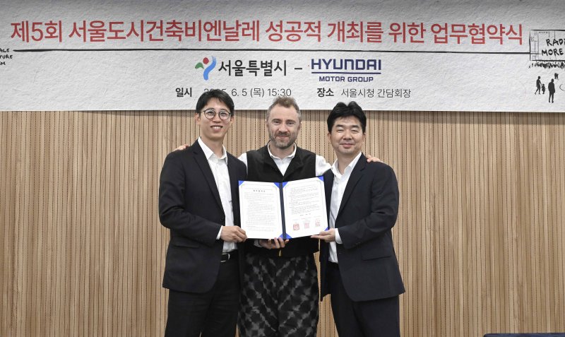 안중욱 서울시 미래공간담당관(왼쪽부터), 토마스 헤더윅 총감독, 홍래욱 현대차그룹 글로벌디자인매니지먼트팀 상무가 지난 5일 서울시청에서 열린 업무협약식에서 기념 촬영을 하고 있다. 현대자동차그룹 제공