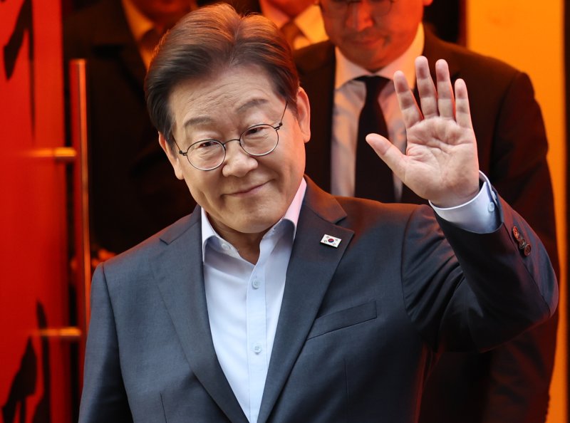 이재명 더불어민주당 대통령 후보가 5월 1일 서울 종로구의 한 포차 식당에서 '당신의 하루를 만드는, 보이지 않는 영웅들'이란 주제로 열린 배달 라이더, 택배 기사 등 비(非)전형 노동자들과 간담회를 마친 뒤 나서며 손인사를 하고 있다. (공동취재) 2025.5.1/뉴스1 ⓒ News1 이재명 기자