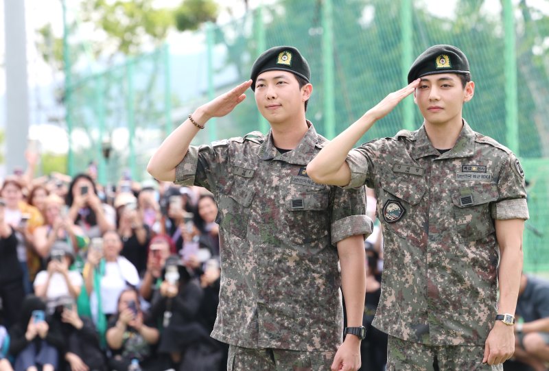 방탄소년단(BTS)의 RM(김남준, 30)과 뷔(김태형, 29)가 10일 오전 강원도 춘천시 신북읍 체육공원 축구장에서 군 복무를 마친 뒤 전역 인사를 하고 있다. ⓒ News1 권현진 기자